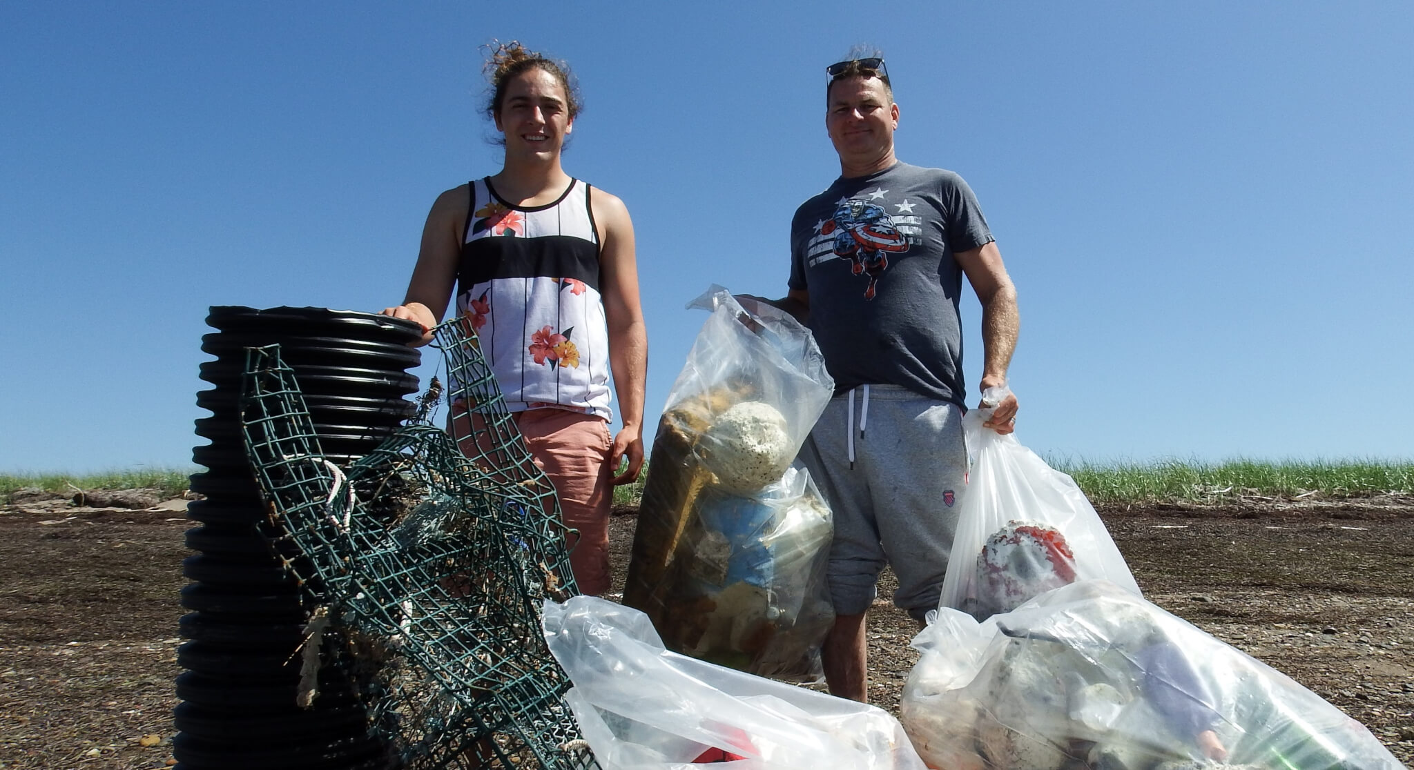 Summer student and Lewnnany collect trash on the beach